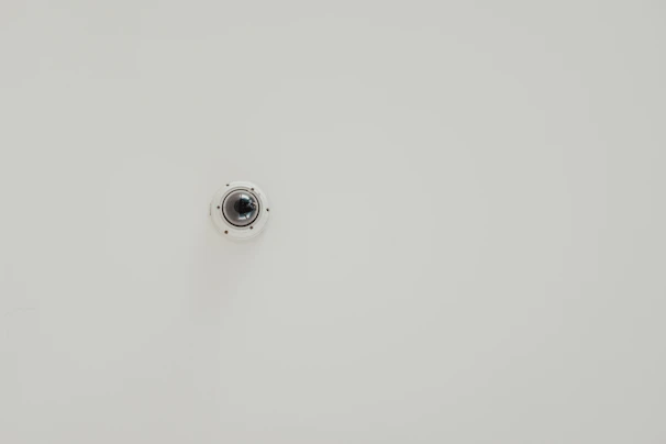 Compact 4K PTZ camera mounted on a conference room wall.
