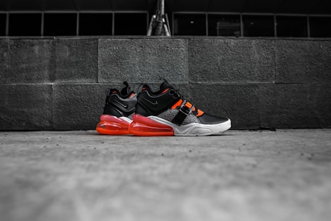 black-and-red Nike athletic shoes on gray floor