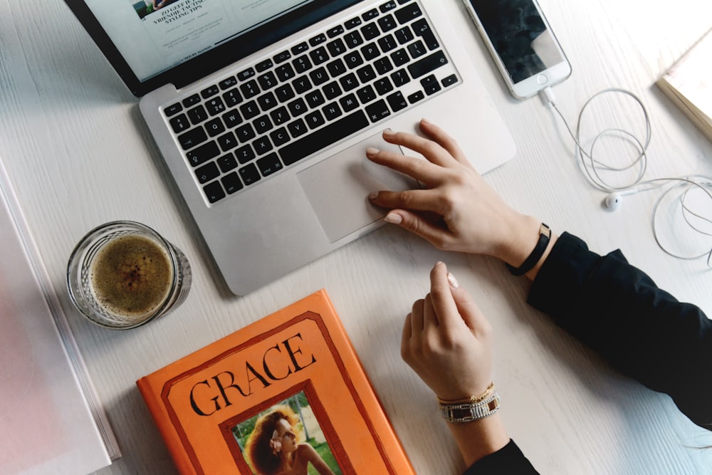 Person click on a website using her Macbook Pro