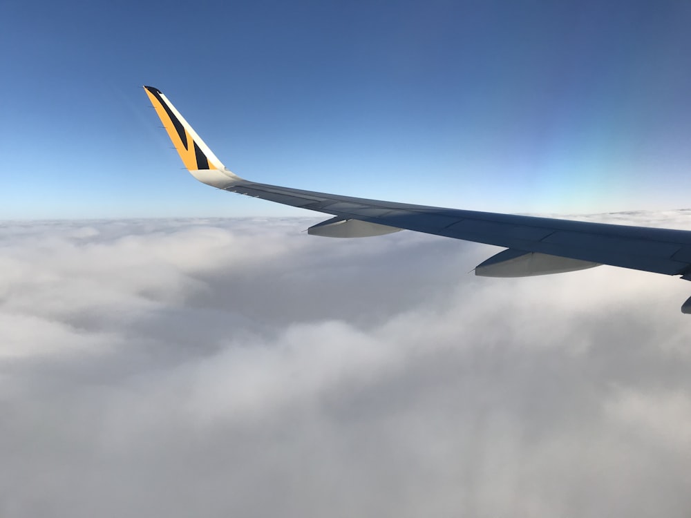 white airplane wing over cloudy skies
