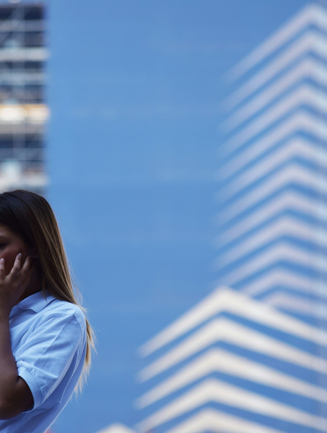 woman in white shirt standing near white and blue building during daytime