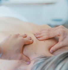 person massaging the back of a woman