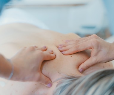 person massaging the back of a woman