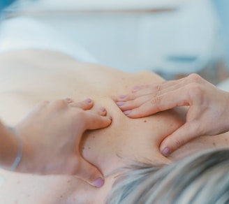 person massaging the back of a woman