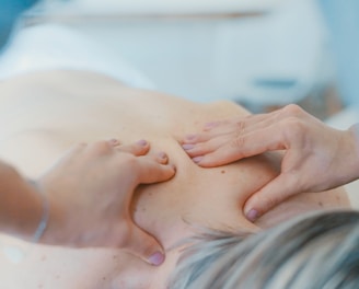 person massaging the back of a woman