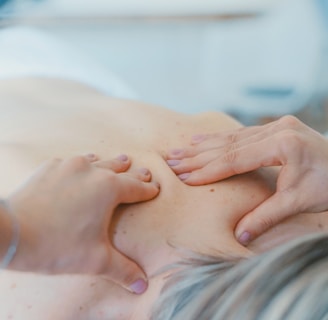 person massaging the back of a woman