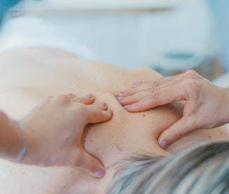 person massaging the back of a woman