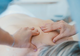 person massaging the back of a woman