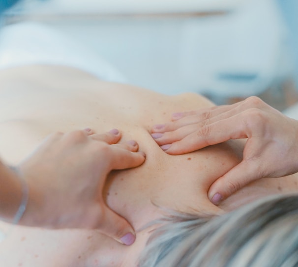 person massaging the back of a woman