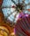 An ornate, domed glass ceiling with intricate designs is the background of a festive installation featuring a large, colorful Christmas tree ornament with stripes and various colors. Surrounding the tree are hanging, oversized decorations shaped like candies, creating a whimsical, holiday-themed atmosphere.