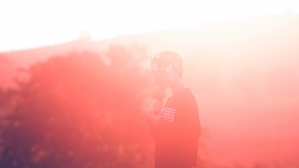 a man standing in a field with trees in the background