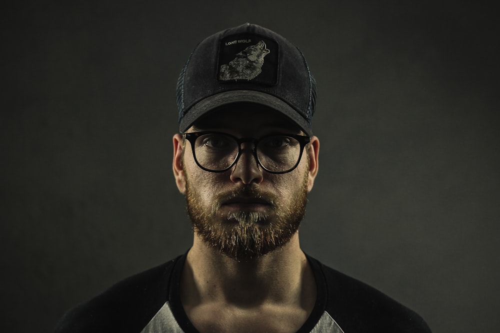 man wearing black curve brim cap and clear eyeglasses with black frames