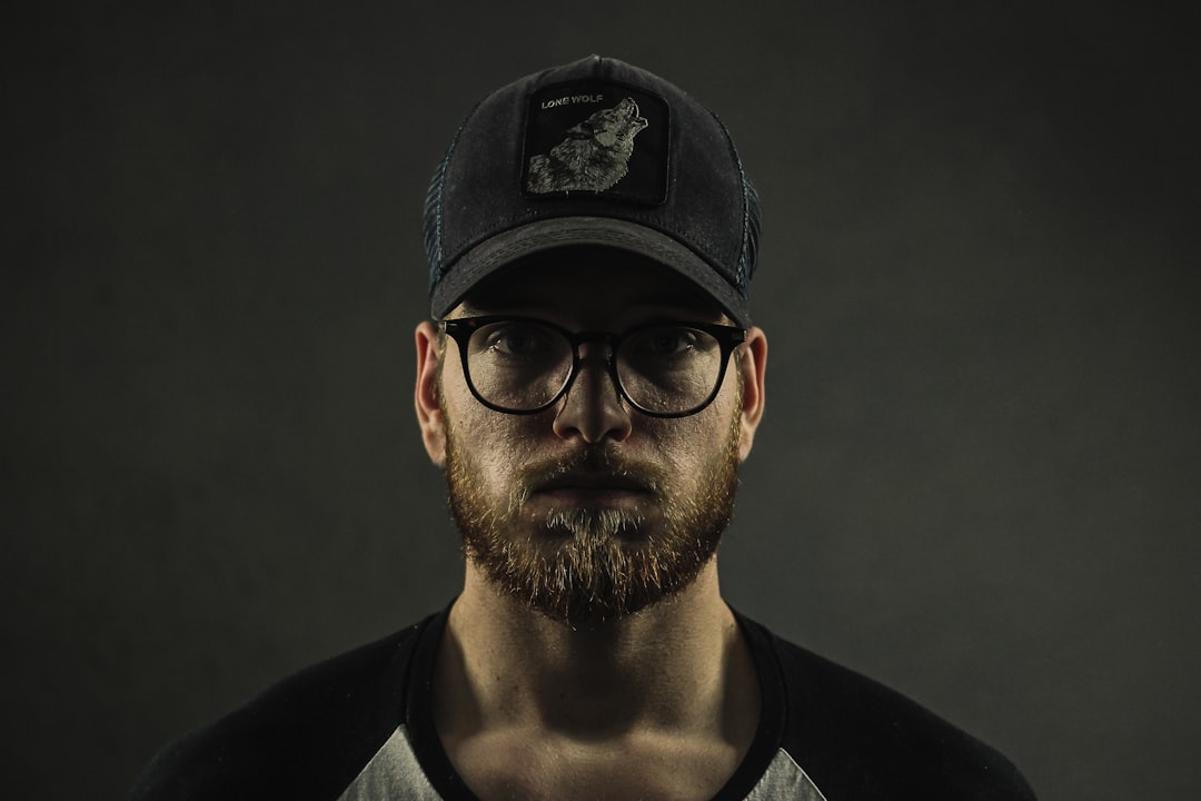 man wearing black curve brim cap and clear eyeglasses with black frames