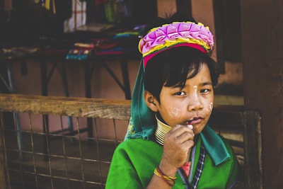 A child twirling in colorful ethnic wear at a festive outdoor market.