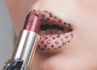 woman putting lipstick on lips