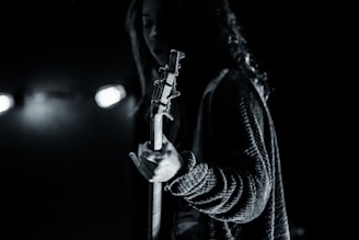 Close-up of Shivam Madaan playing guitar under dim, moody lighting with dark tones.