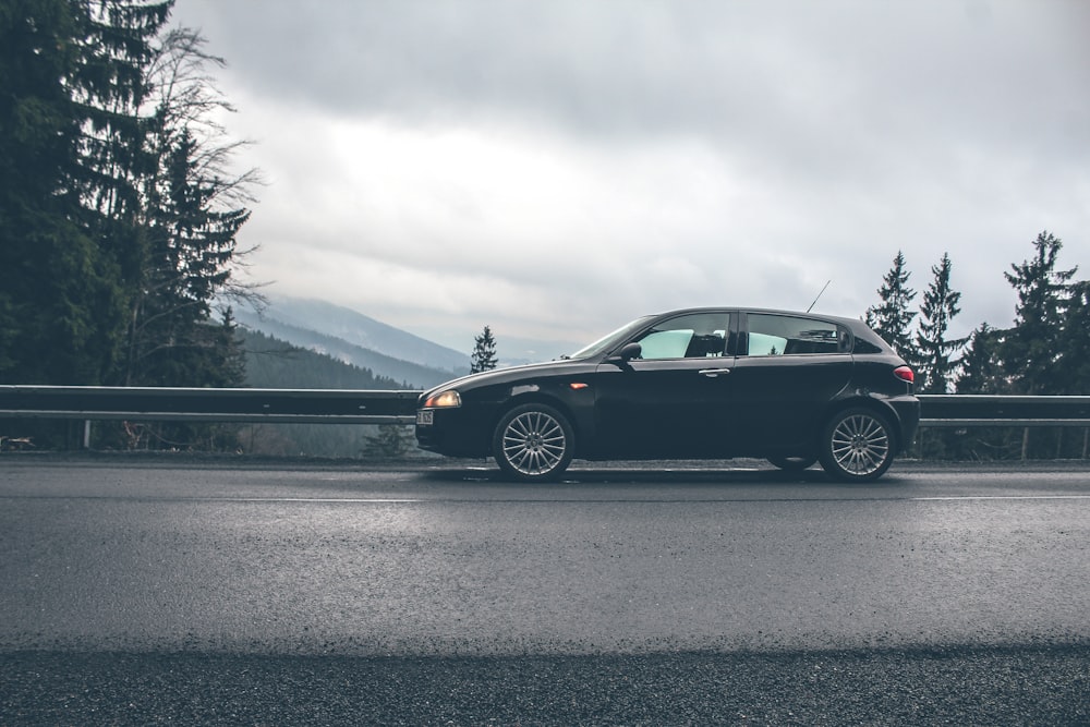 Coche negro cerca de los rieles de la carretera