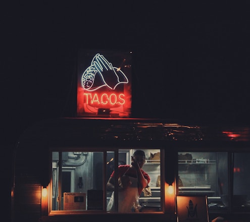 A vibrant food truck serving tacos in a lively setting.