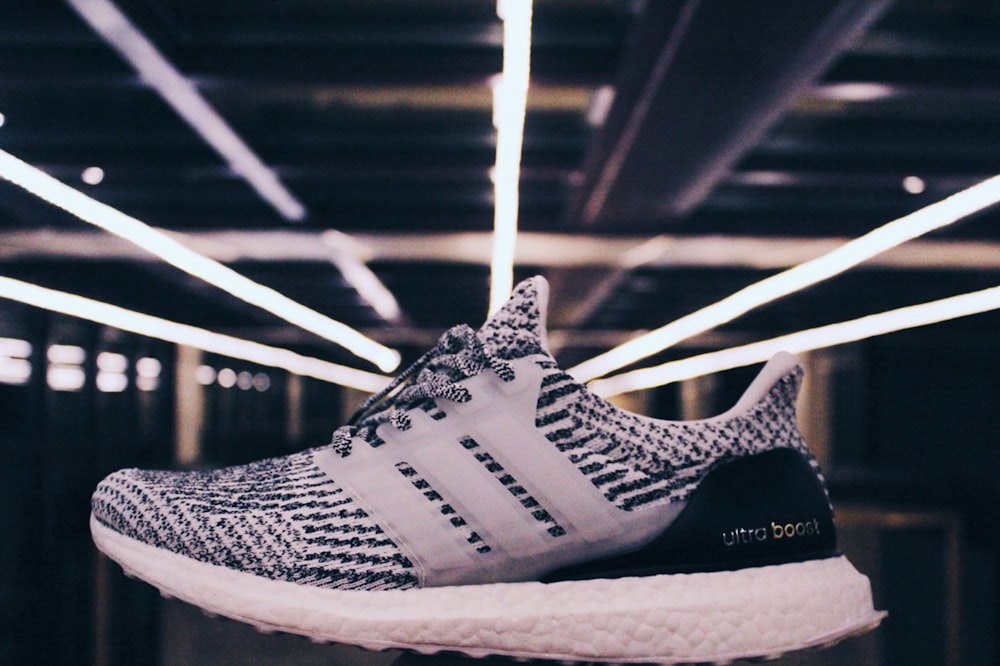 unpaired white and black adidas ultraBOOST shoe