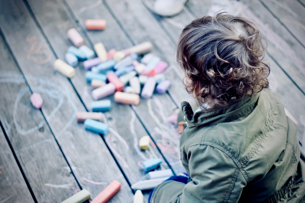 personne assise devant des stylos de couleurs assorties