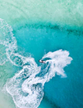 A vibrant jetski speeding across clear Adriatic waters under a bright sunny sky
