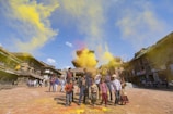 Children playing with balloons and festival-themed face paint in a lively park.