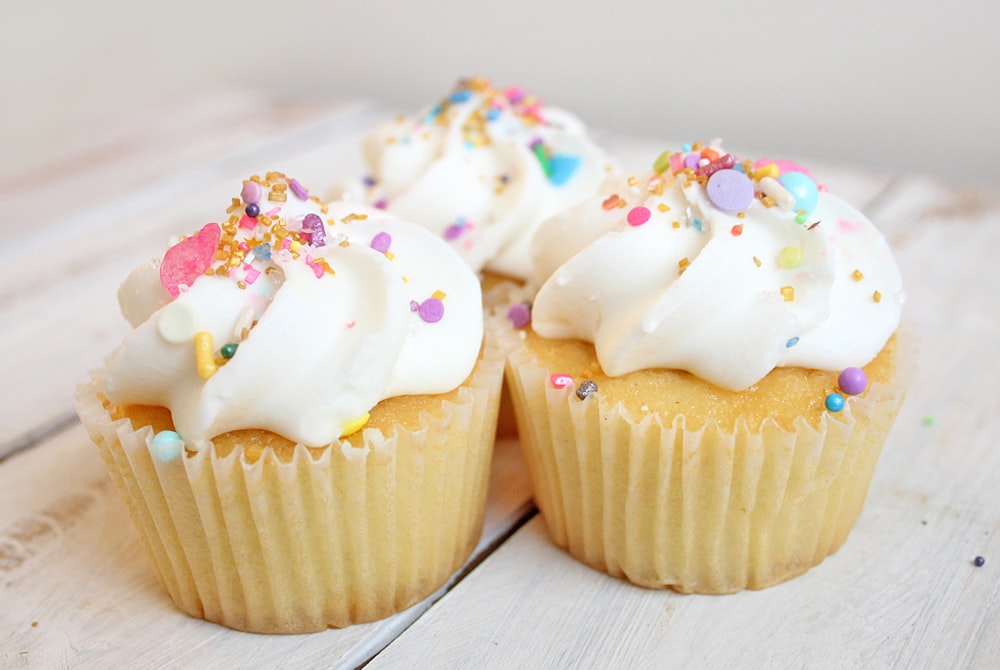 Trois cupcakes sur bois blanc