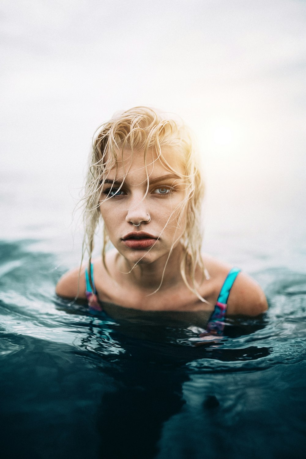 donna che indossa costume da bagno blu sullo specchio d'acqua