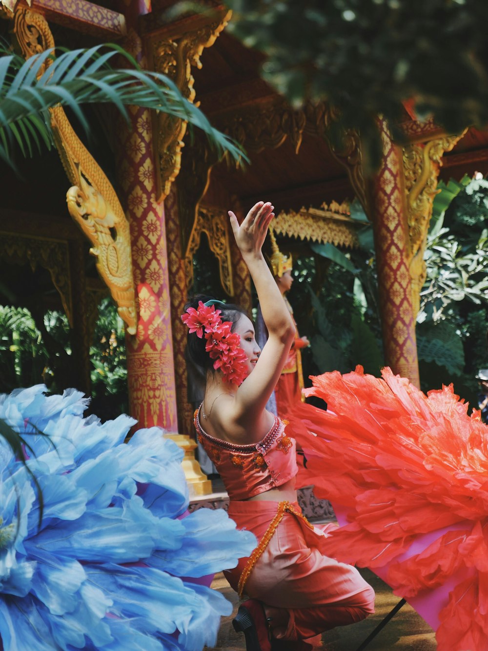 woman standing beside red flower decorations