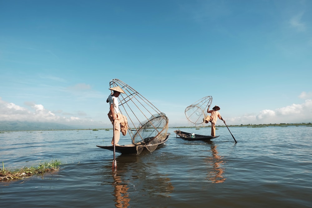 dos hombres montando bote en el cuerpo de agua