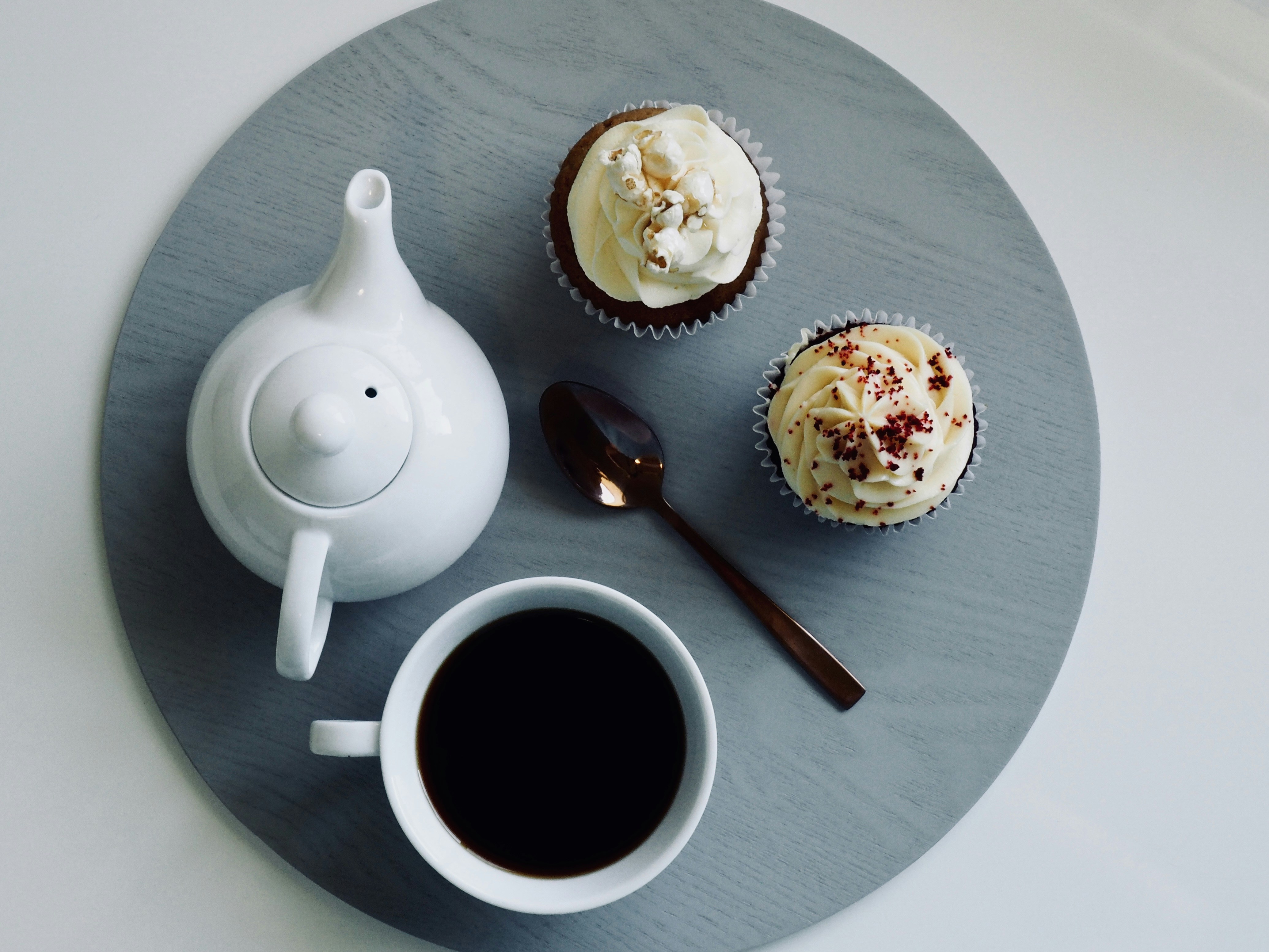 white ceramic teapot beside brown spoon