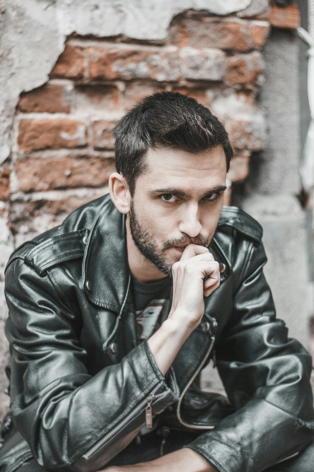 man sitting while biting his right middle finger