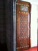 Close-up of a mosque’s ornate wooden door featuring traditional Islamic geometric patterns.