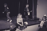 A group of students performing a theatrical play on stage.