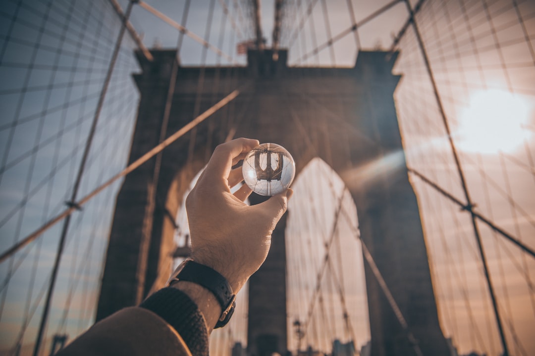 Brooklyn Bridge and sphere held up in the sunlight to show perception