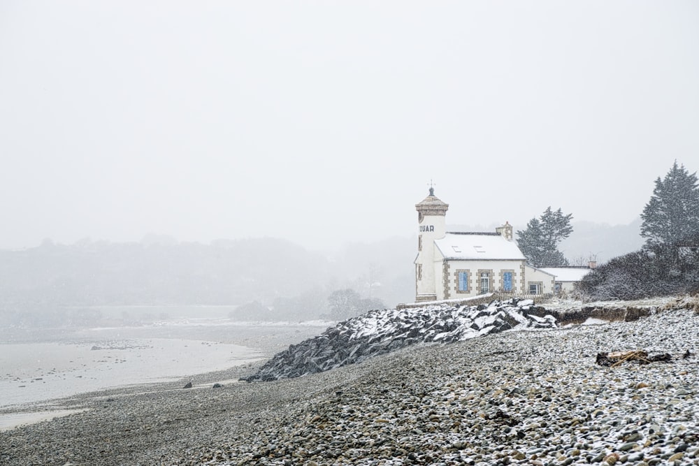 white concrete church near body of water and trees during daytime