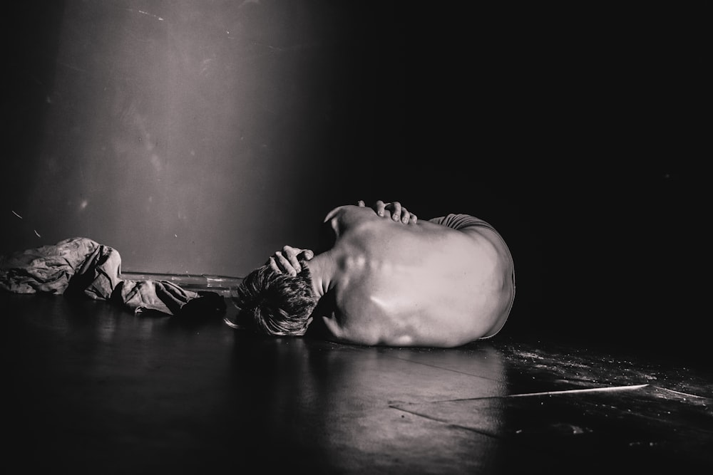 grayscale photography of man lying on floor