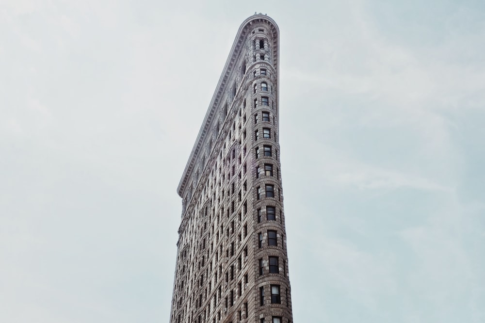 bâtiment gris sous un ciel nuageux pendant la journée