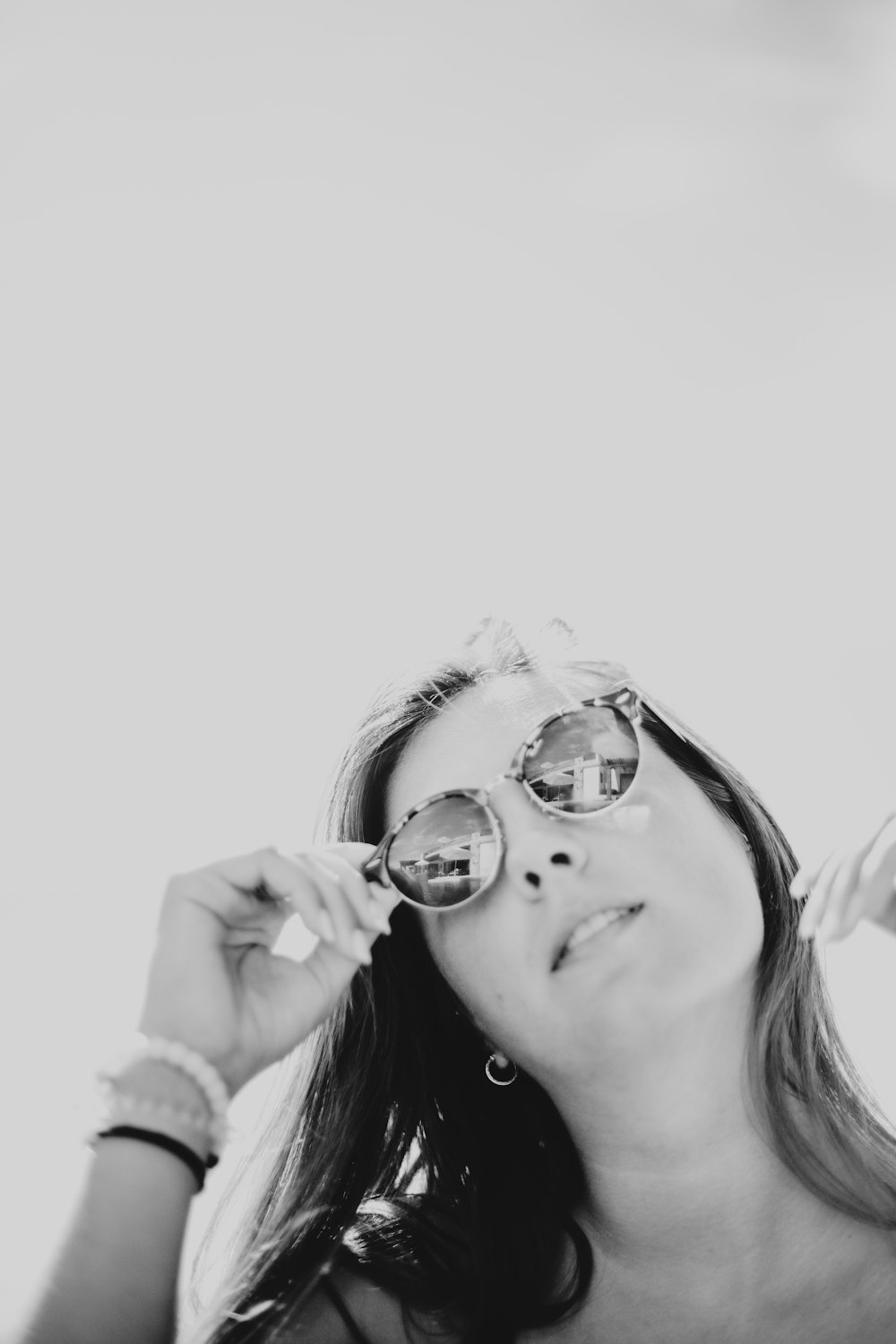 grayscale photo of woman holding sunglasses