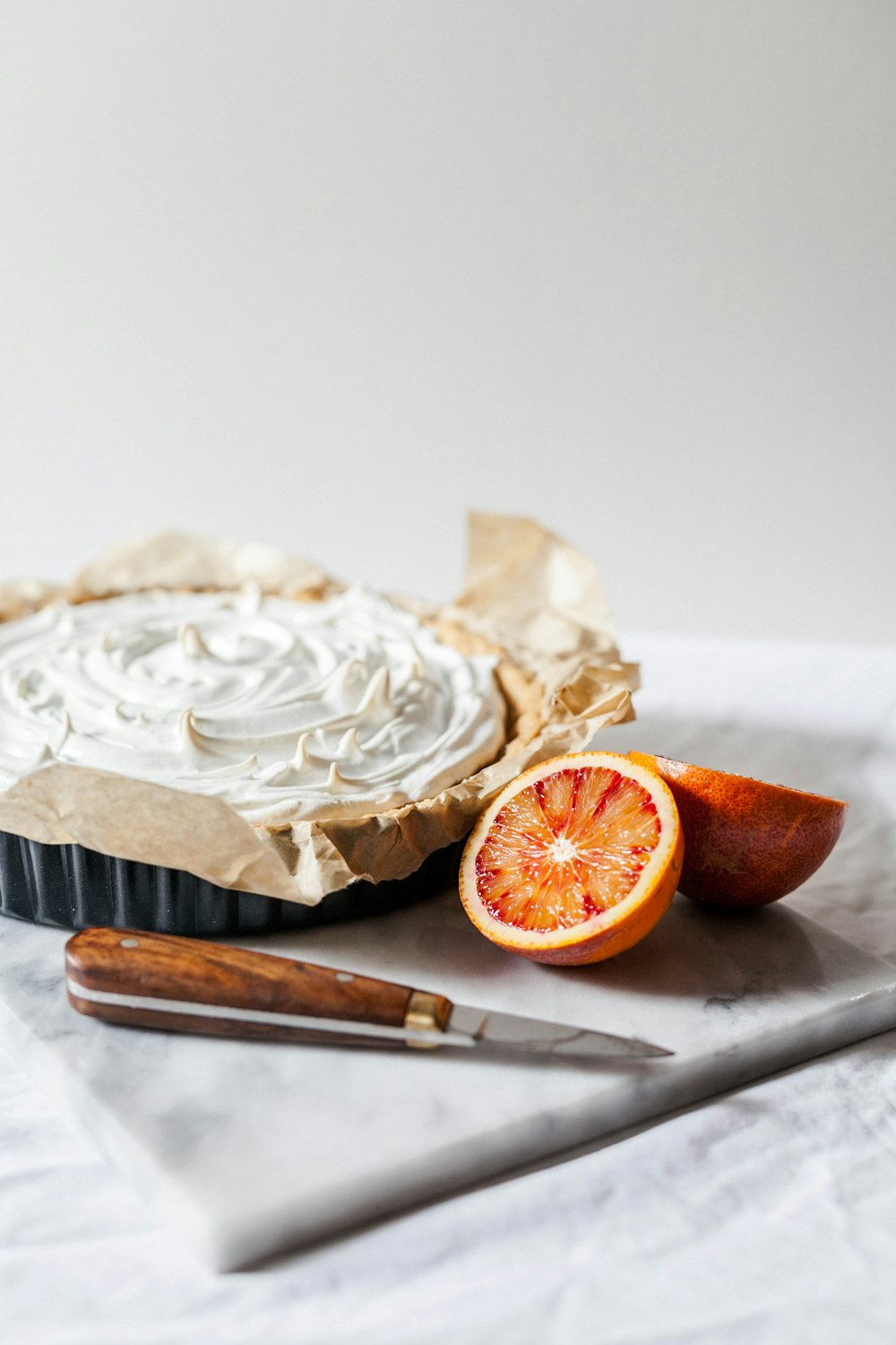 geschnittene Orangenfrüchte und weißer Cupcake