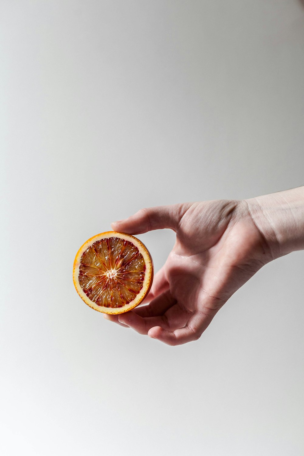 person holding sliced grapefruit
