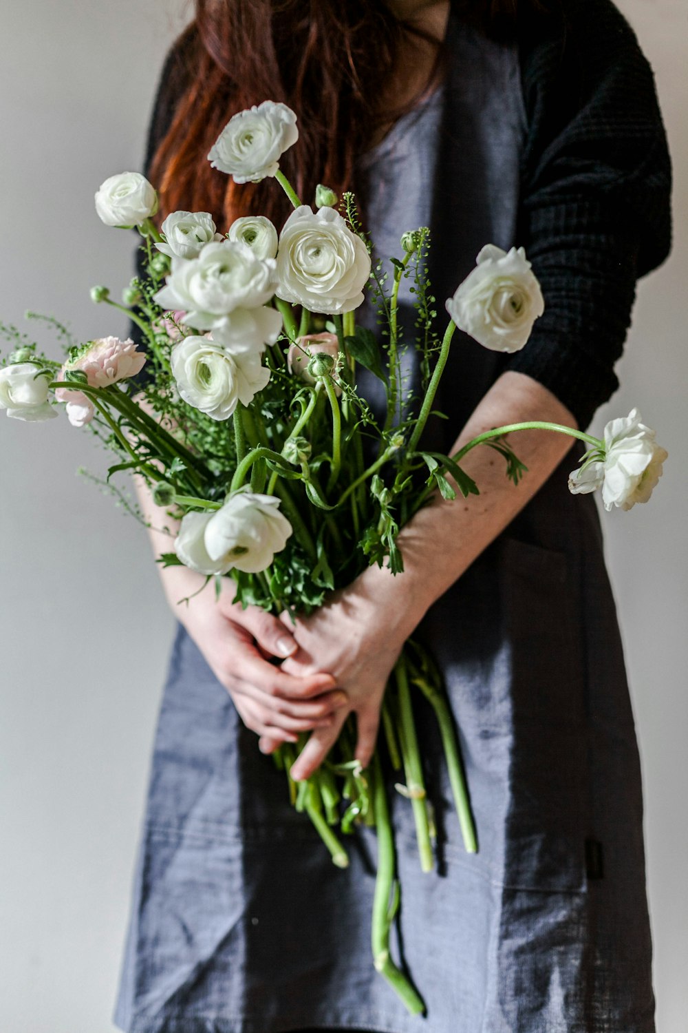 Mujer sosteniendo rosas blancas