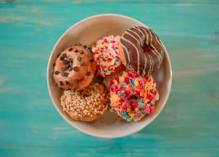 seven assorted-flavor doughnuts on brown ceramic bowl
