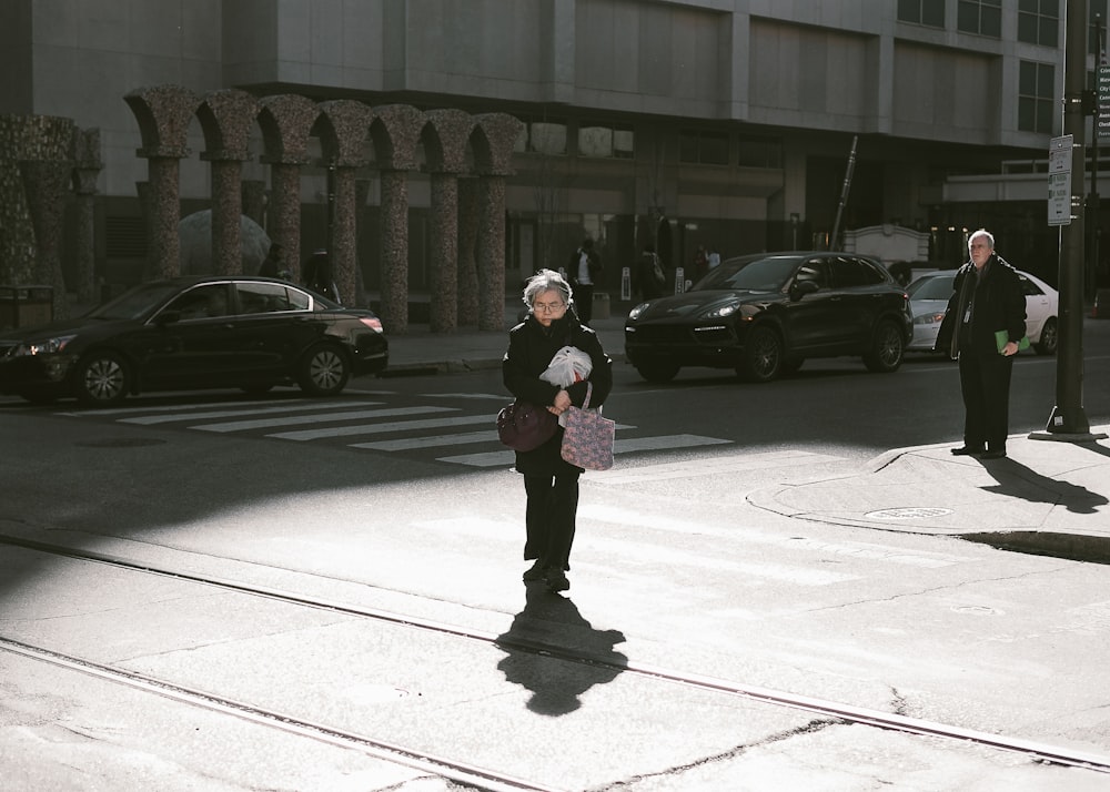 woman walking along street wearing black coat