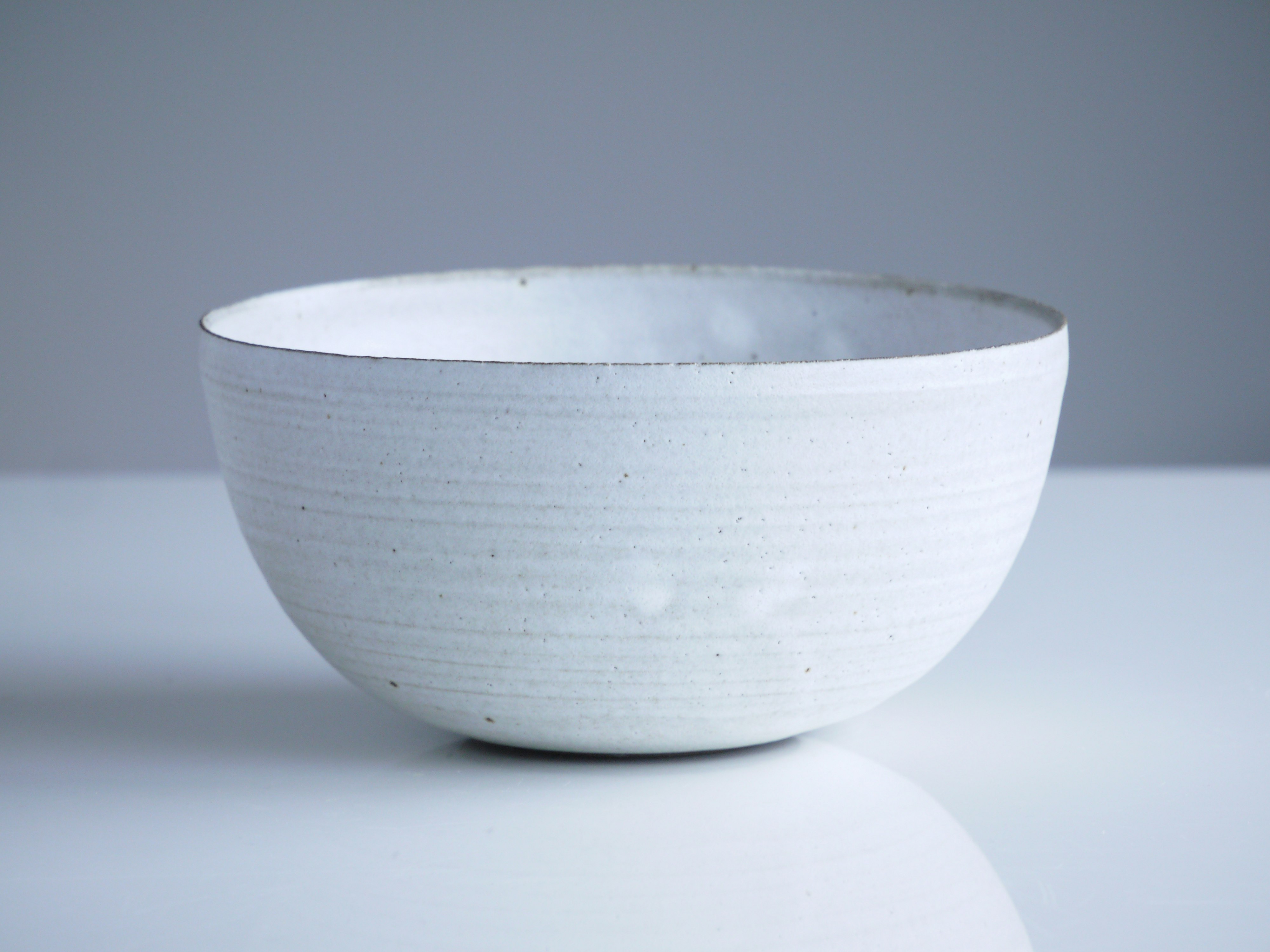 This bowl is made of black clay and covered in a white frost glaze, I’ve taken the phot on our dining table at home. We have large floor to ceiling windows that are north facing, so we get a soft light, that is actually the most beautiful on a slightly grey day.