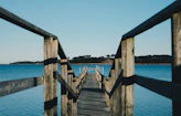 empty brown wooden sea dock under blue sky