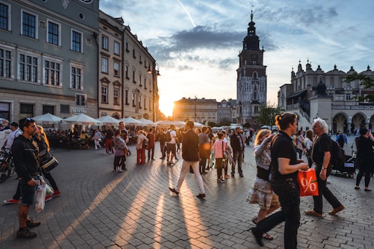 people walking on street near concrete buildings in Town Hall Tower Poland