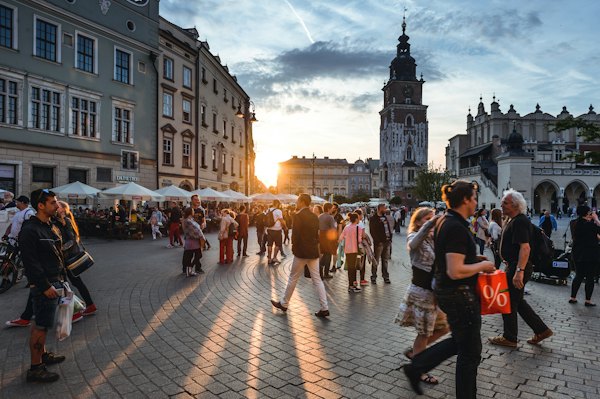 People walking on street near concrete buildings — Krakow, Poland