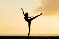 A striking silhouette of a dancer against a twilight cityscape.