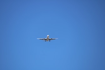 low angle photography of gray airplane under blue sky at daytime